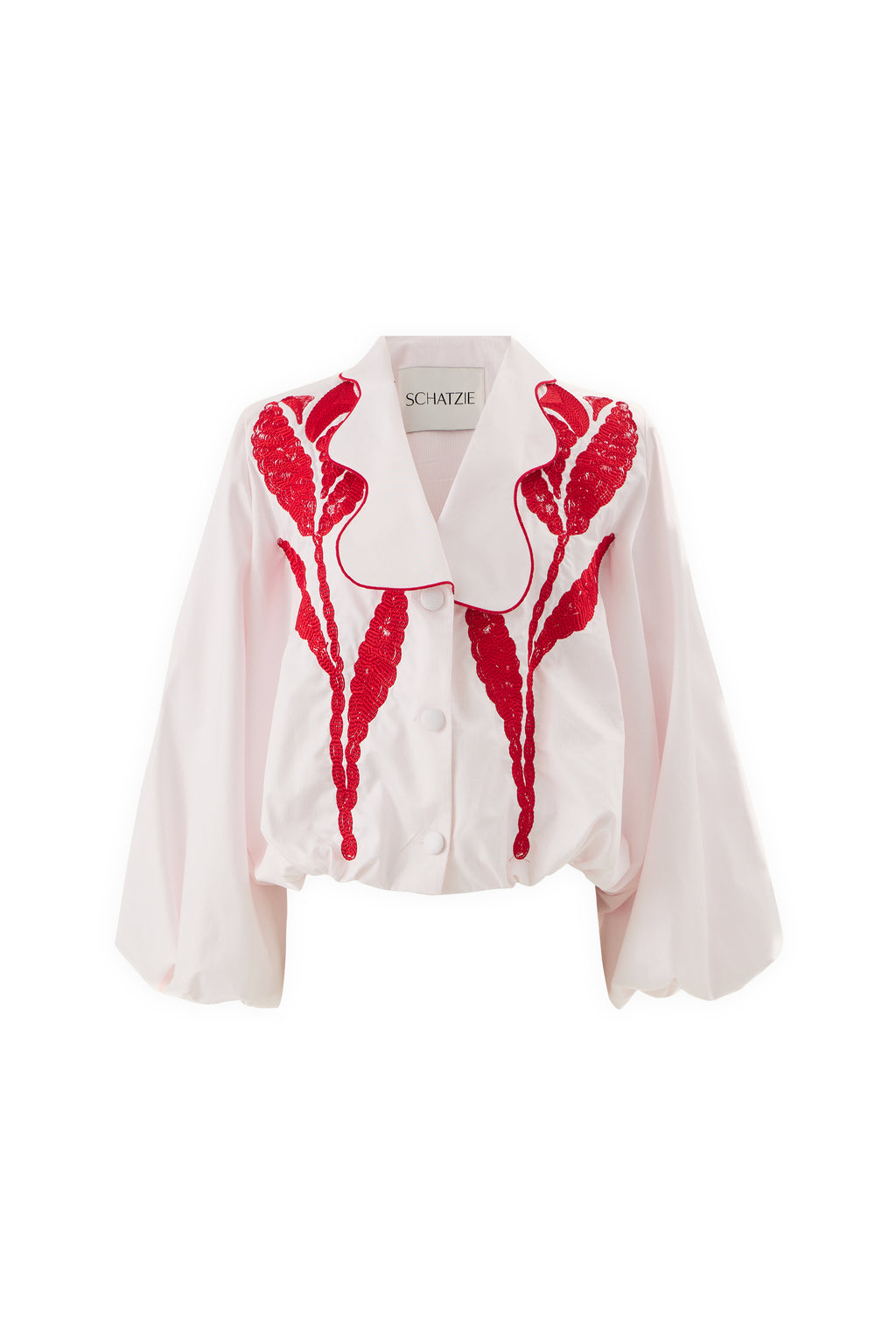 The SCARLET TULIP JACKET features a white, blouse-style silhouette with wide sleeves, a large collar, and red sequin leaf embellishments on the front for a standout look. The inside label reads SCHATZIE.