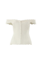 The IVORY MUSE TOP is an off-the-shoulder white corset with scalloped edges, wave embroidery on the neckline, sleeves, and hem, a sculpted silhouette, and a back zipper closure.